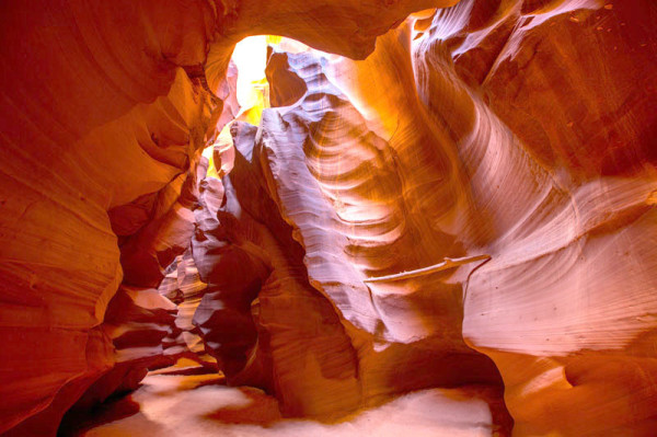 Ein Ahnenforscher-Hobby: die USA. Im Bild sieht man Sandstein in herrlichen Rottönen und in Wellen. Man sieht von oben die Sonne  hinein scheinen.
